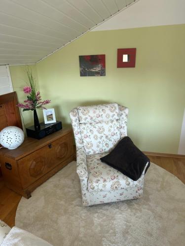 a living room with a chair and a vase on a table at Ferienwohnung Miesseler in Kall