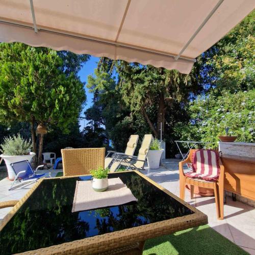 a patio with a table and chairs and an umbrella at Relax Dream Villa-House, Apartement, Studio in Kallithea Halkidikis