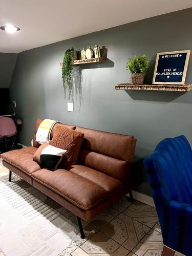 a brown leather couch sitting in a living room at Chicago-Pilsen Boho apartment with Free parking - Unit C in Chicago