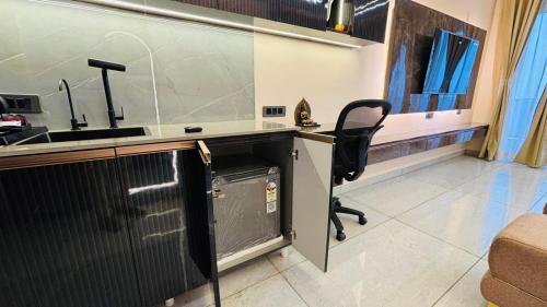 a kitchen with a sink and a desk with a chair at Chalo Chaley Luxury Stays in Ghaziabad