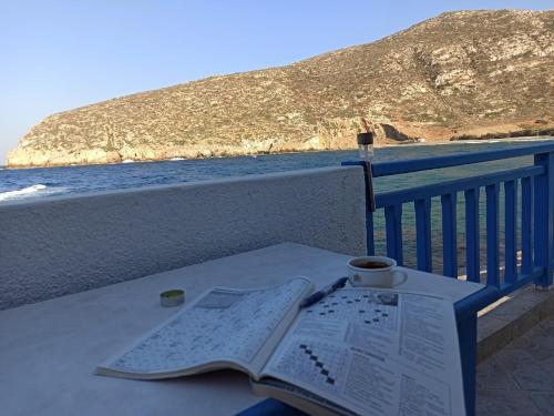 an open book on a table on a balcony with the ocean at By the Sea! in Apollon