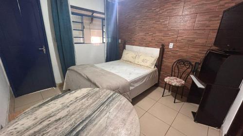 a small bedroom with a bed and a chair at Acomodação Bicentenária - qrts parte baixa da casa - Rua Casa da Ópera in Ouro Preto