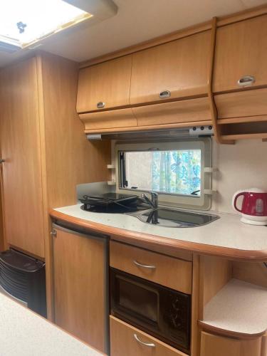 a kitchen with a stove and a microwave in it at Maszoperia Sun4hel Kite & Wind & Surf in Jastarnia