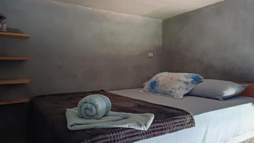 a bed with two pillows on top of it at Green Belly Surf Hostel in El Paredón Buena Vista