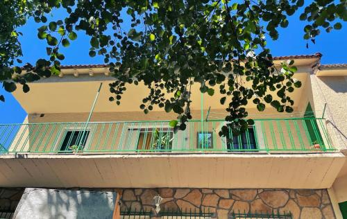 a building with a green balcony on the side of it at Casa La Garganta, en plena naturaleza in Piedralaves