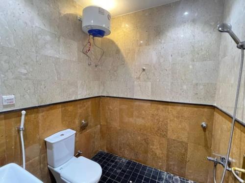 a bathroom with a white toilet and a shower at A privet room in AL Rawda in Quai