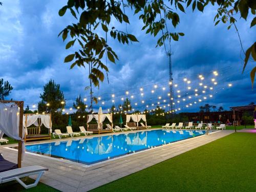 a swimming pool with lounge chairs and lights at Hotel Aeetes Kobuleti in Kobuleti