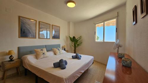 ein Schlafzimmer mit einem Bett mit zwei blauen Handtüchern darauf in der Unterkunft Oasis Marino in El Borseral