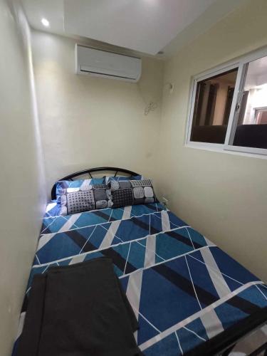 a bedroom with a bed with a blue and white floor at Check & Travel in Olongapo