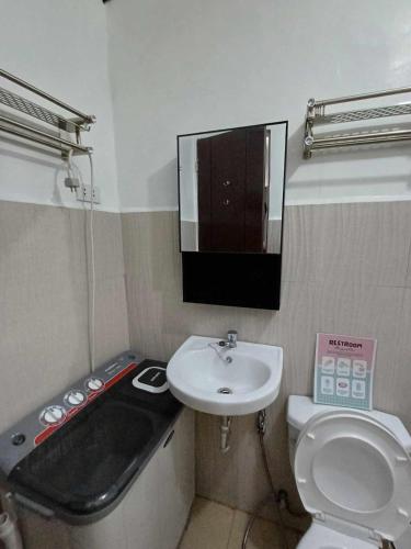 a bathroom with a sink and a bath tub and a toilet at Check & Travel in Olongapo