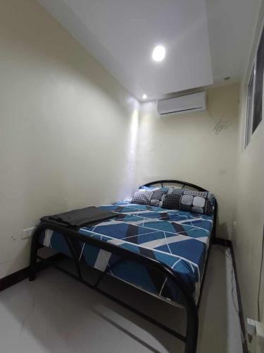 a small bedroom with a bed in a room at Check & Travel in Olongapo