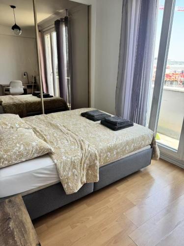une chambre avec deux lits et une grande fenêtre dans l'établissement Appart Plein Soleil Seine Paris 5ème Jardin Plantes, à Paris