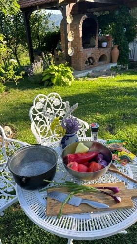 a table with a bowl of fruits and vegetables on it at Conacul Paloși in Horezu