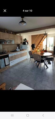 a kitchen and dining room with a table and chairs at La Cachette de la baie in Pontorson