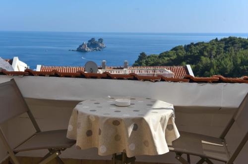 a table and chairs on a balcony with a view of the ocean at Vila Apartments Lidija in Petrovac na Moru