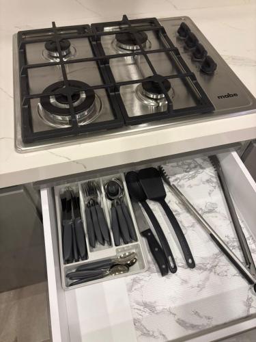a stove top oven sitting on top of a counter at Elegante departamento a 10 minutos de Cintermex in Monterrey