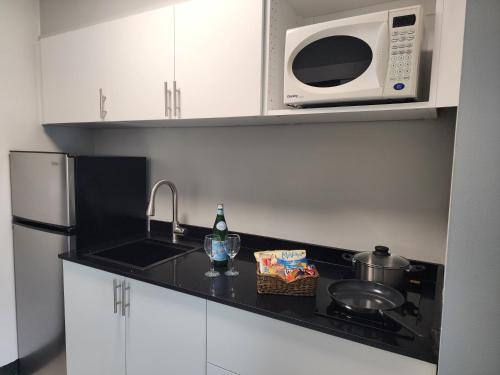 a kitchen with a sink and a microwave at Windsor Motel in Hope