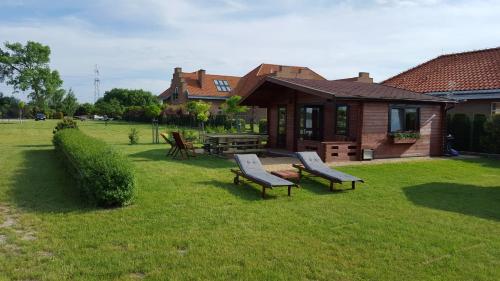 a yard with two benches and a house at Aparthotel EuforiaPort in Pisz