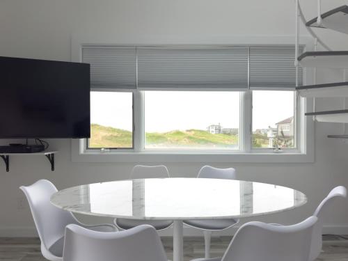 a white dining room with a white table and chairs at Windward Shores in Amagansett