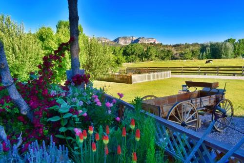 a garden with flowers and a wooden cart at Arrowhead Country Cabins in Mount Carmel