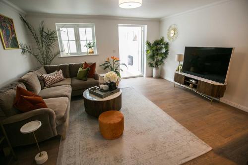 a living room with a couch and a flat screen tv at Your home away from home in Bury Saint Edmunds