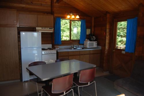 a kitchen with a refrigerator and a table and chairs at La Conner Camping Resort Deluxe Cabin 5 in La Conner