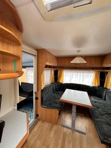 a living room with a table and a couch in a trailer at Maszoperia Sun4hel Kite & Wind & Surf in Jastarnia