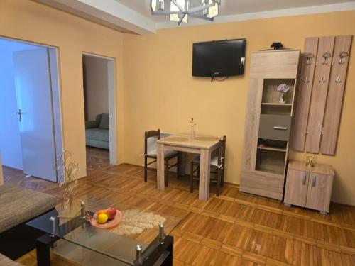 a living room with a table and a tv on the wall at Тишина и покой в Будве in Kravlja