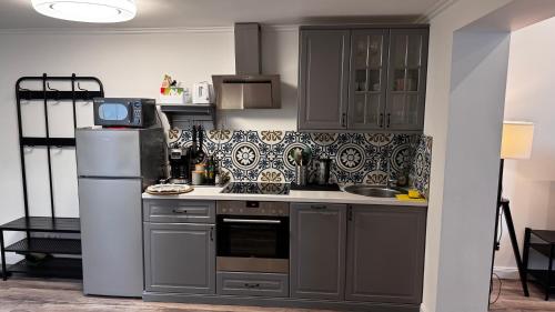 a kitchen with gray cabinets and a refrigerator at Apartment A&A in Niederdorf