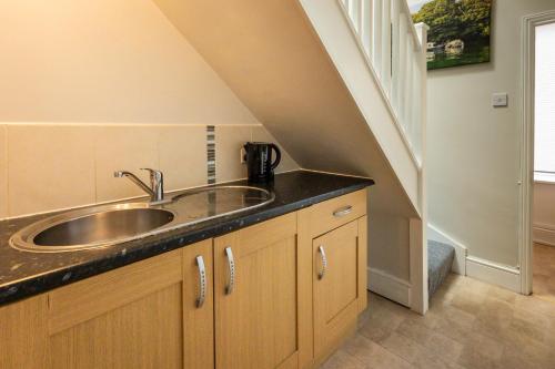 a kitchen with a sink and a staircase at Stylish Urban Retreat- Fast WiFi & Private Ensuite in Bristol