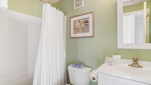 a bathroom with a white toilet and a sink at Windward Shores in Amagansett