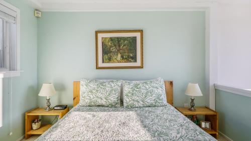 a bedroom with a bed with two lamps and a picture on the wall at Windward Shores in Amagansett