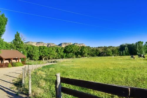 a field with a fence and mountains in the background at Arrowhead Country Cabins in Mount Carmel