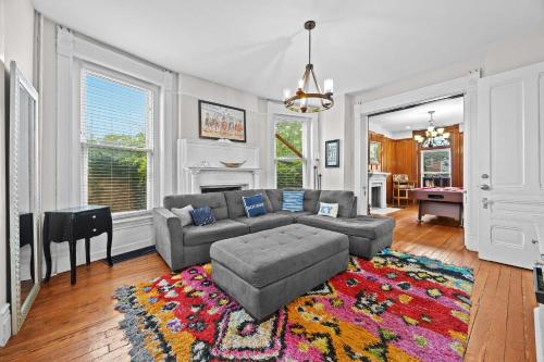 una sala de estar con un sofá y una alfombra en Historic 3-BR Downtown Bourbon Getaway, en Louisville