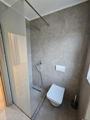 a bathroom with a shower with a toilet and a glass shower at Hotel Petro in Vlorë