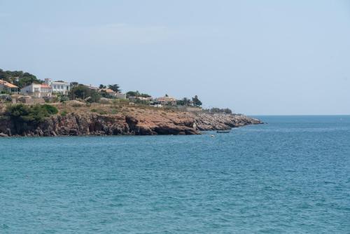 an island in the ocean with houses on a hill at Corniche Azur YourHostHelper in Sète