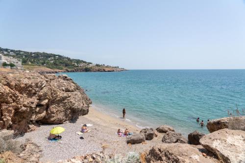 a group of people on a beach near the water at Corniche Azur YourHostHelper in Sète