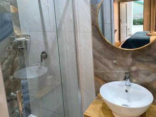 a bathroom with a sink and a mirror at Bel-Air Guesthouse in Klerksdorp