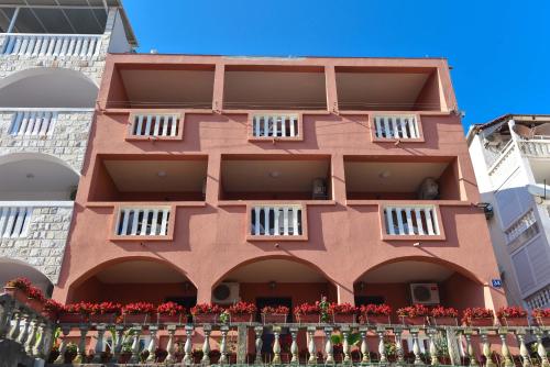 a building with red flowers in front of it at Vila Apartments Lidija in Petrovac na Moru
