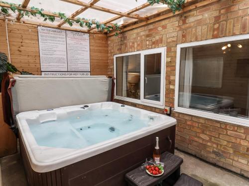 a jacuzzi tub in a building with two windows at Tennyson House in Scarborough