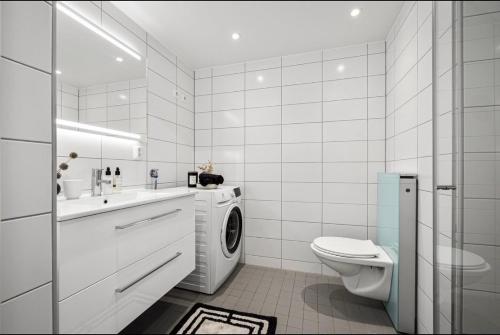 a white bathroom with a washing machine in it at Moderne leilighet i Lørenveien in Oslo