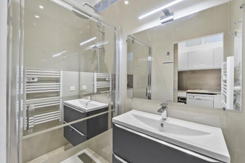 une salle de bain blanche avec deux lavabos et un miroir dans l'établissement Centre de Cannes 2 Bedrooms, 131 Rue d'Antibes à 5 minutes du palais, à Cannes