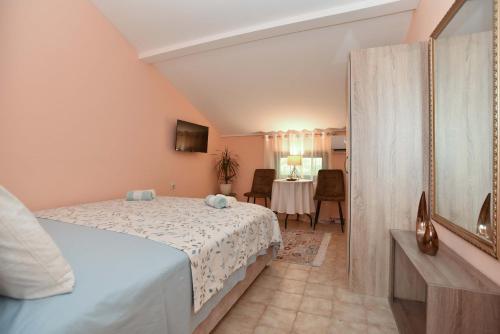 a bedroom with a bed and a table in a room at Vila Apartments Lidija in Petrovac na Moru