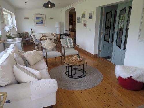 a living room with a white couch and a table at Danesfort House in Balnacart