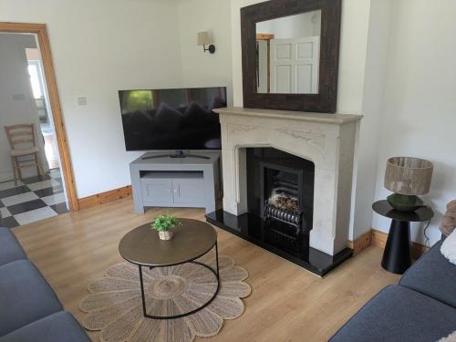 a living room with a fireplace and a tv at Danesfort House in Balnacart