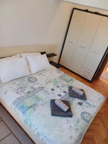 a bed with two towels and a pair of sandals on it at APARTMAN MiG in Vranje