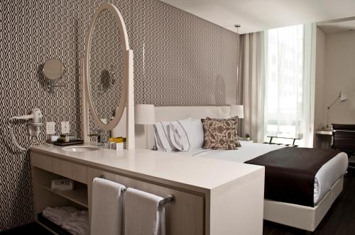 a bedroom with a bed with a sink and a mirror at Exe Bacata 95 in Bogotá