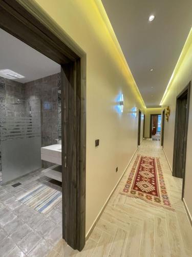 a hallway with a bathroom with a sink and a rug at Soso beach villa in Durat Alarous