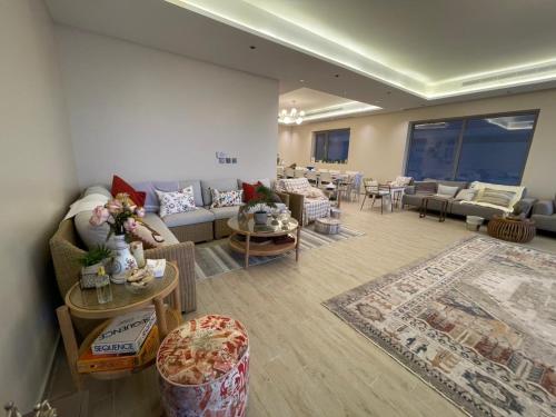 a living room with a couch and tables and chairs at Soso beach villa in Durat Alarous