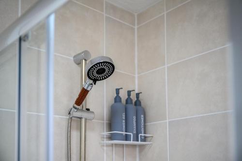 a shower with a blow dryer in a bathroom at 3BDR Gated parking near city centre in Manchester